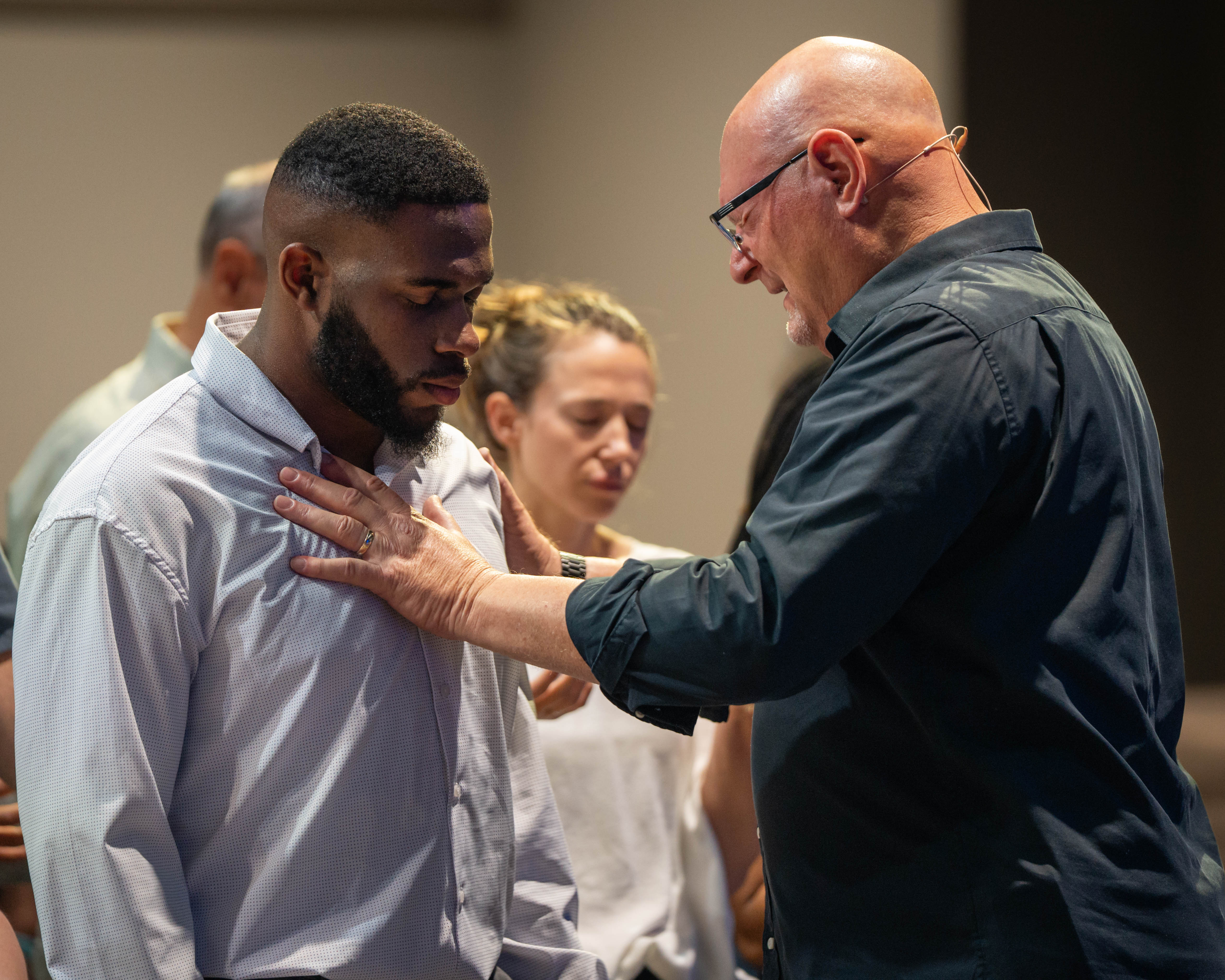 Victory Church leader praying over a member