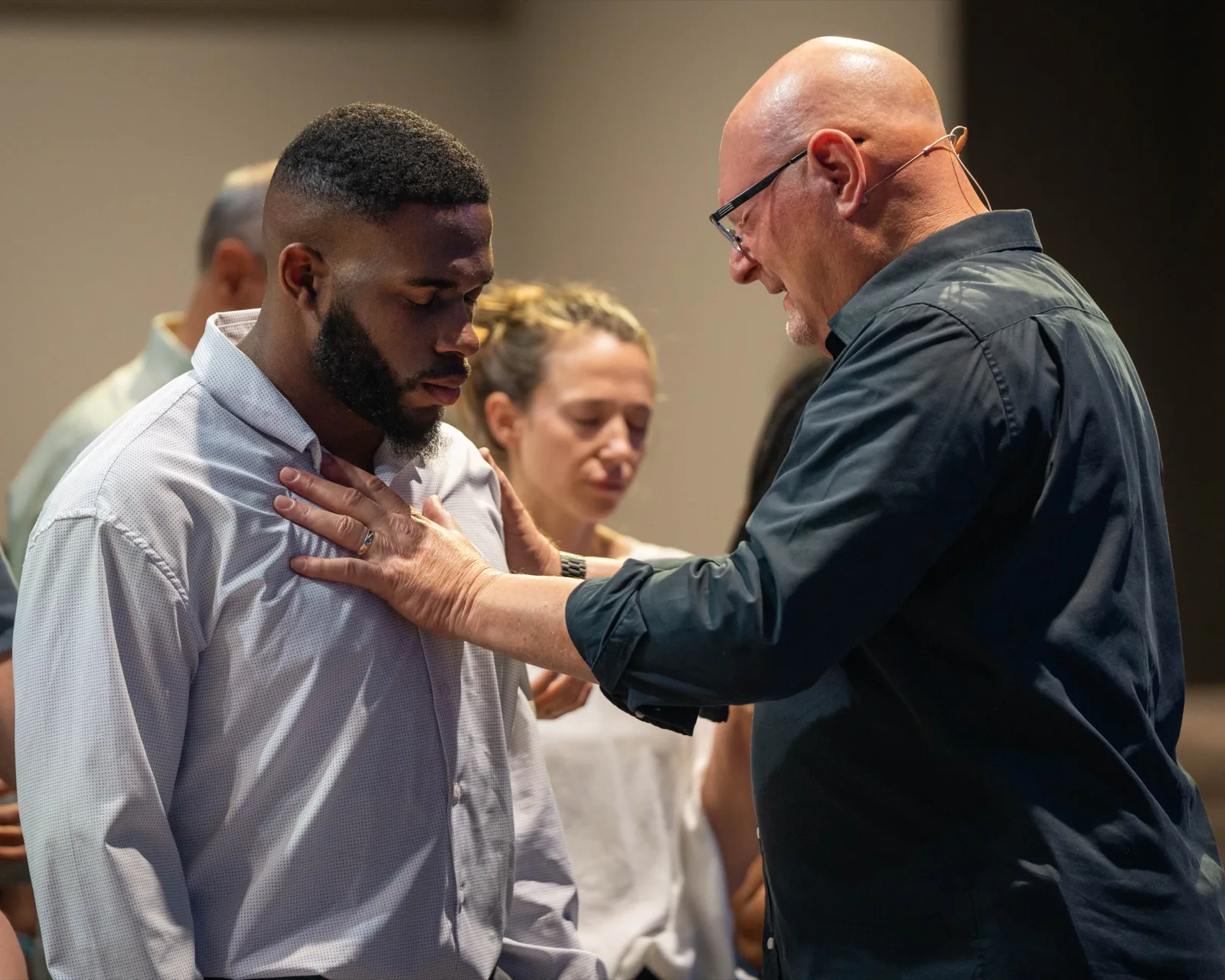 Victory Church leader praying over a member